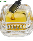 Image of OG Kush CBD Live Resin dripping from a dab tool into a calyx container.